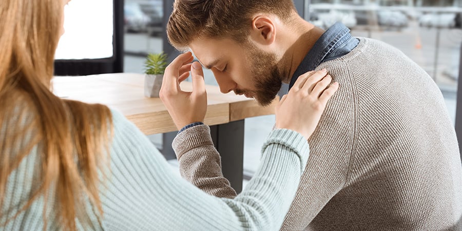 Worried Man being comforted by a female